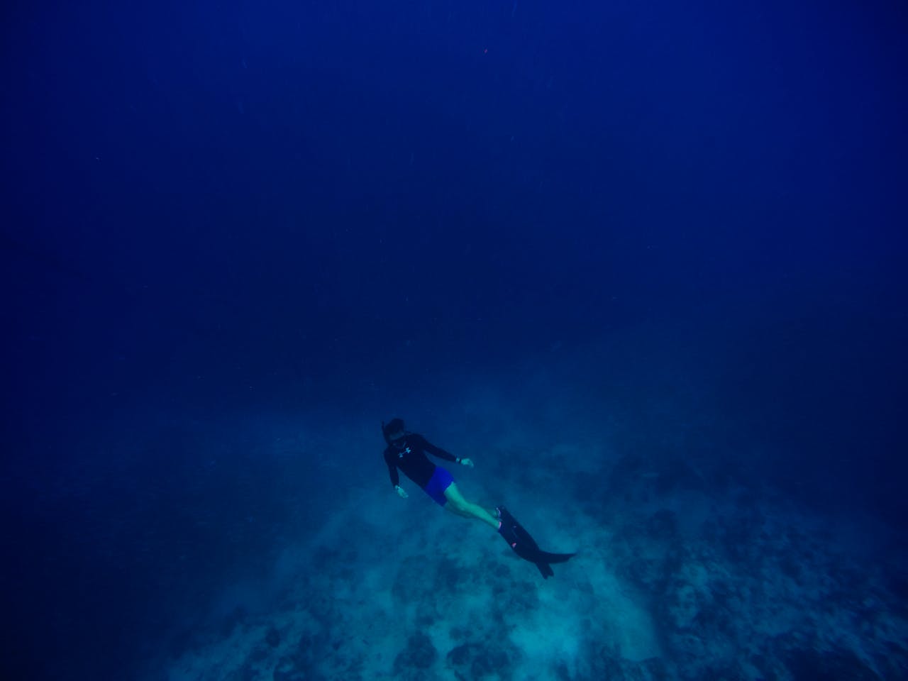 Scuba diver exploring the deep blue ocean depths, showcasing marine adventure.